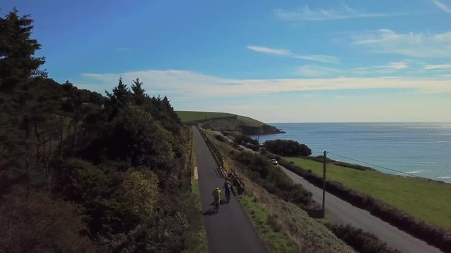 Couple Cycling Along The Ocean Coast. Waterford Greenway In Ireland 