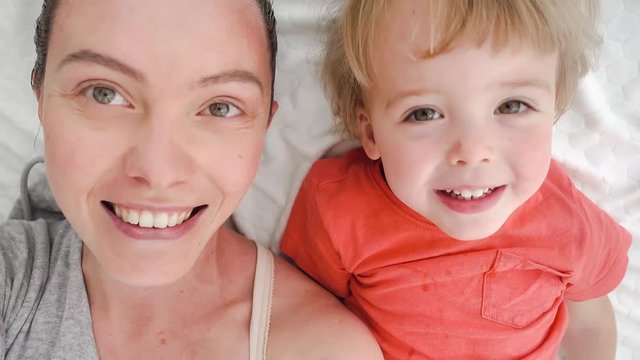 Mother and baby boy doing selfie on bed. Resting in bed together. Maternity concept. Parenthood. Motherhood Beautiful Happy Family Stock Video Footage.