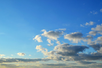 Light white clouds high in a blue sky on a sunny day background