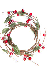 A top view of  christmas  round twigs with leaves and red berries on red background