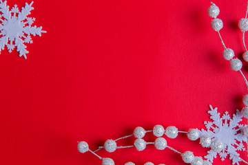 A top view of white christmas ornaments: a branch of white twigs and snowflakes