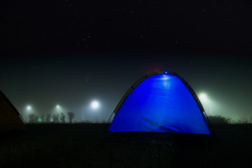 Blue tent with light in night and foggy.