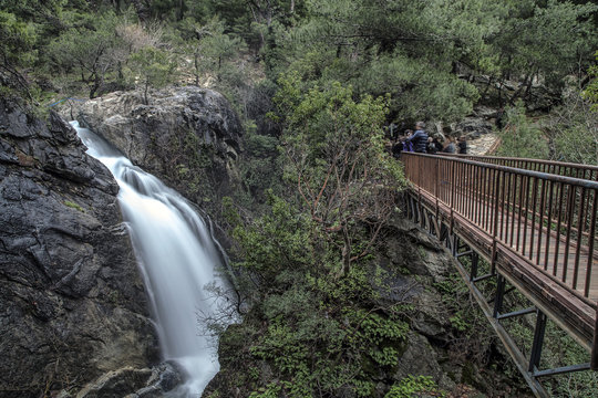 Tourists are taking Sutuven Waterfall's photos from the bridge. On Ida Mountains in Zeytinli