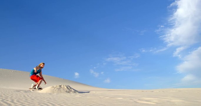 Man performing a jump while sand boarding 4k