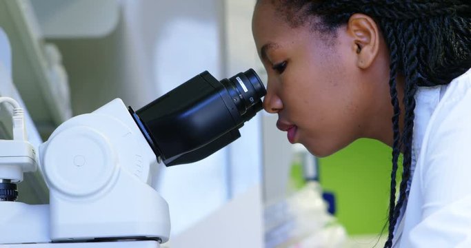 Scientist looking through microscope 4k