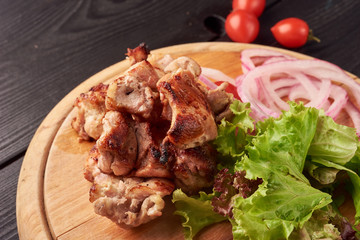 Barbecue skewers with juicy meat and salad and tomatoes on plate
