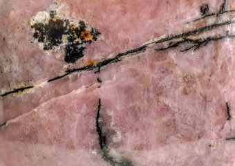 Stone texture background. Polished rhodonite gemstone macro.