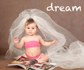 Little baby girl as a bride with a magazine