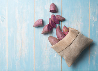 Fresh purple cassava on wood background