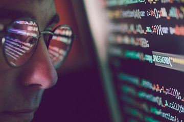 Hacker using computer, smartphone and coding to steal password and private data