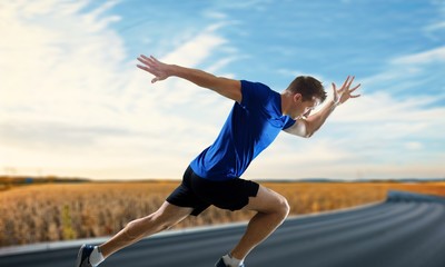 Young sporty man running isolated on white