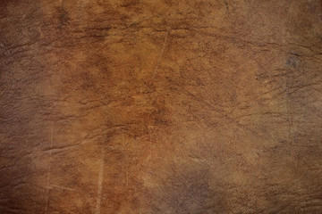 Textured background of worn brown leather upholstery