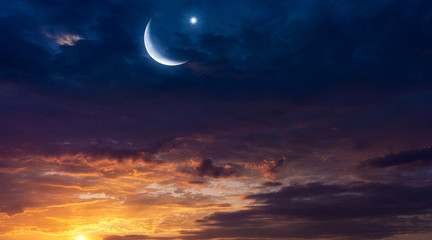 Naklejka na ściany i meble Crescent moon with beautiful sunset background . Light from sky . Religion background . beautiful sky . Yellow and pink clouds . Sunset and new moon . Prayer time . Generous Ramadan