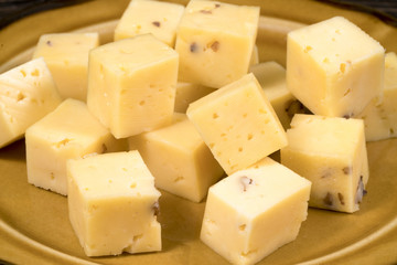 cheese cubes in a plate on a wooden background