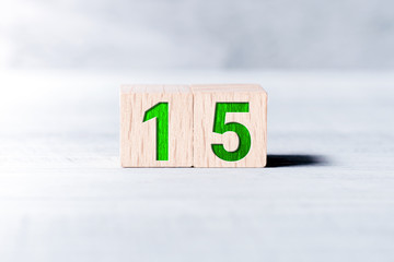 Number 15 Formed By Wooden Blocks On A White Table