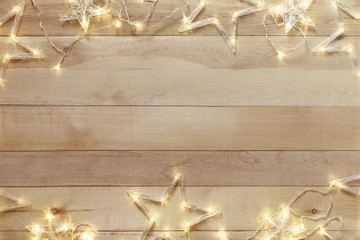 Wooden christmas background with bright garland. Copy space.