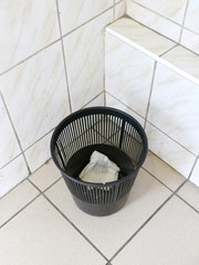 plastic urn in the toilet on the floor