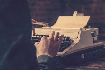 Young businessman typing on an antique vintage typewriter machine - Powered by Adobe