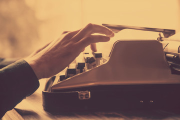 Journalist  typing on an antique vintage typewriter machine as symbol of remotely work