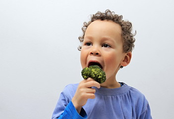 little boy enjoying broccoli stock photo