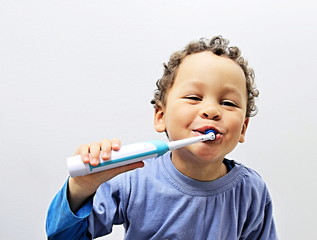 little boy brushing his teeth with an electric tooth brush with people stock image stock photo