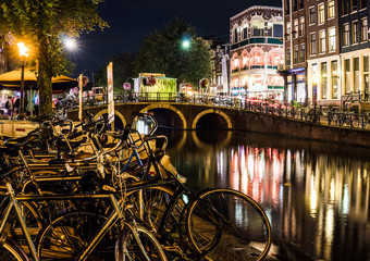 Fototapeta premium Night city view of Amsterdam channel and typical dutch houses, Holland, Netherlands.