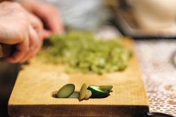 cook cuts a green salad on a cutting Board