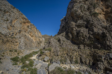 road among green mountains against the blue sky in Crete, Greece