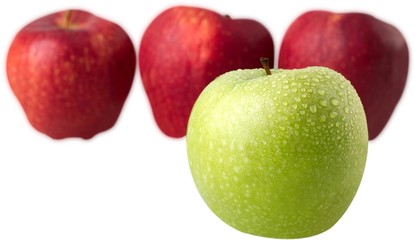 Green Apple in Front of Red Apples