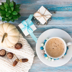 A cup of coffee and colored candies, jewelry boxes, a bracelet with silver charms, succulent and a...