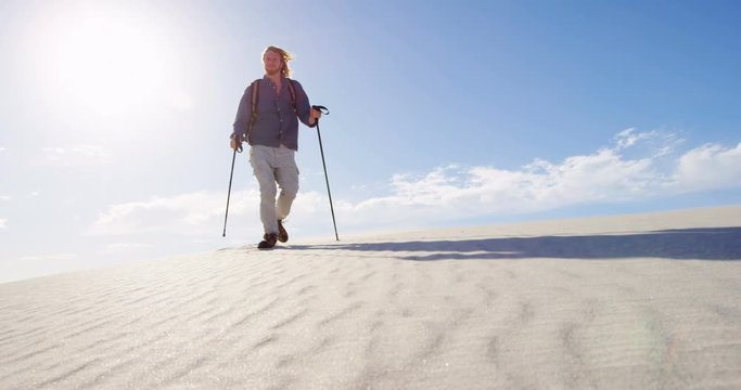 Man with hiking pole walking in the desert 4k