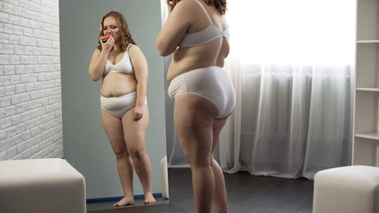 Obese girl crying and eating donut, hopeless trying to lose weight, overweight
