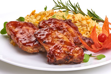 Delicious grilled pork ribs in BBQ sauce with pilaf, isolated on white background. Close-up