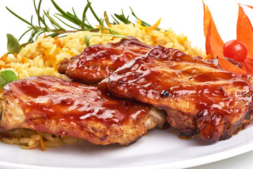 Delicious grilled pork ribs in BBQ sauce with pilaf, isolated on white background. Close-up.