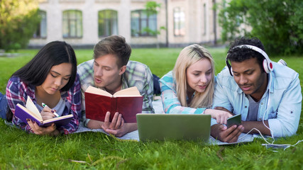 Multiracial students preparing for lessons, talking with each other, education