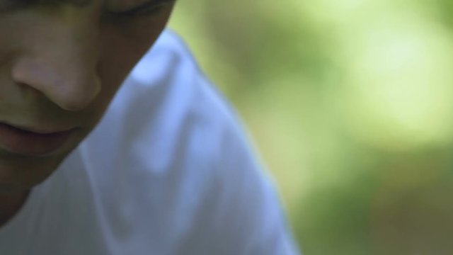 Young female suffering from headache, male calling emergency service in park