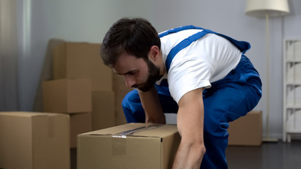 Worker from moving company carrying cardboard box, quality relocation services