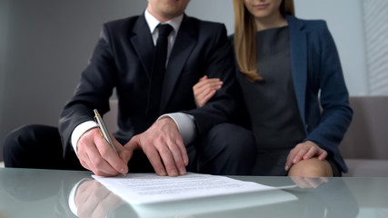 Young couple signing business contract, purchase or sale of property, insurance