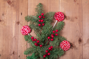 Christmas fir tree on wooden background. Red berries.