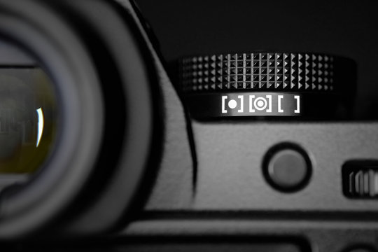 Metering dial of a digital camera in black background.