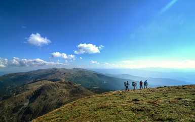 A group of travelers with backpacks travels in the mountains (Goverla mountain, Ukrainian Carpathians)