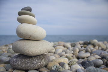 Fototapeta na wymiar Pyramid of sea pebbles on the side of the sea