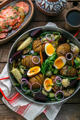 Fototapeta na wymiar Close view of hasselback potatoes and baked vegetables