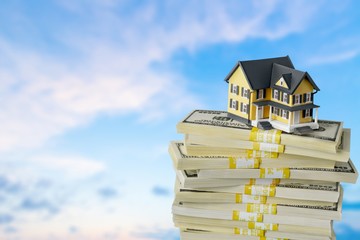 Stack of money with house on background