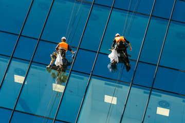 Window washers cleaning the glass facade of a skyscraper