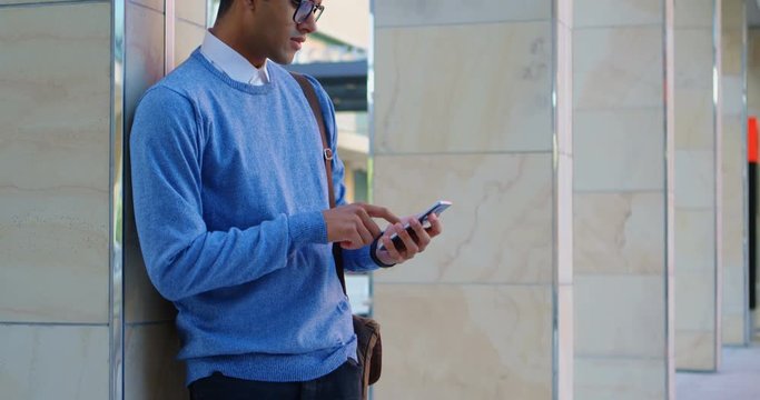 Man using mobile phone against pillar 4k