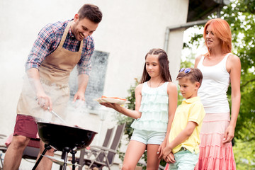 Fototapeta premium Young family make barbecue at their home