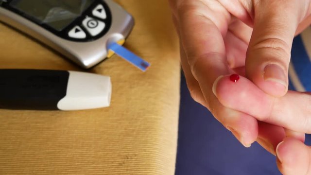4K Pregnant women pricking her finger to test blood sugar glycaemia