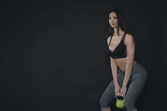 Young female doing swing exercise with a kettle bell. Fitness woman