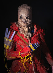 Scary Scarecrow character in a sackcloth suit with syringes on dark background. Cosplay hero